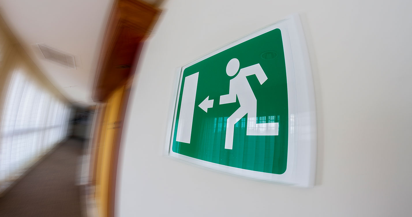 Placa de sinalização de rota de fuga em edificação regularizada